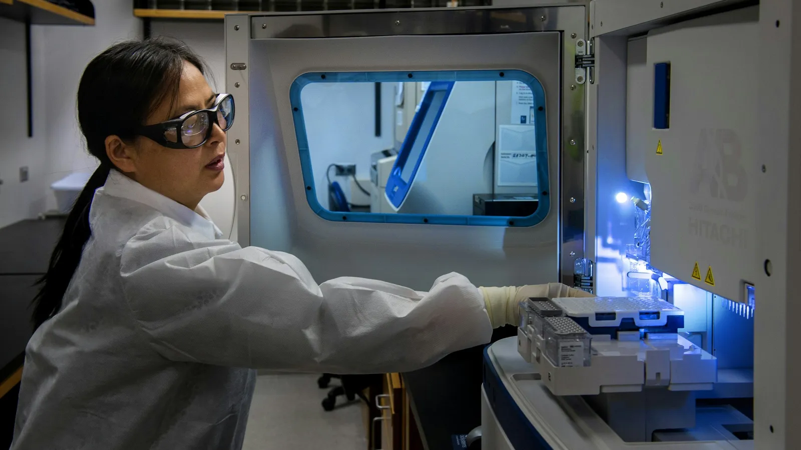 A scientist working at a lab instrument