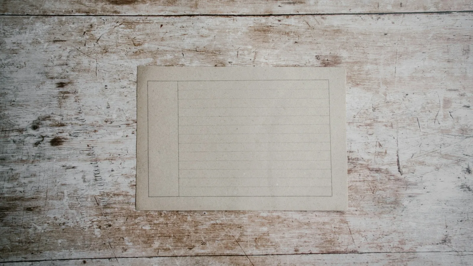 A sheet of graph paper on a weathered wooden table
