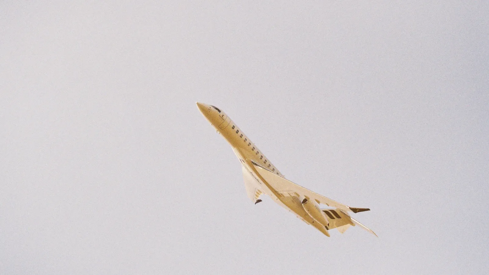 A small aircraft flying against a pale sky