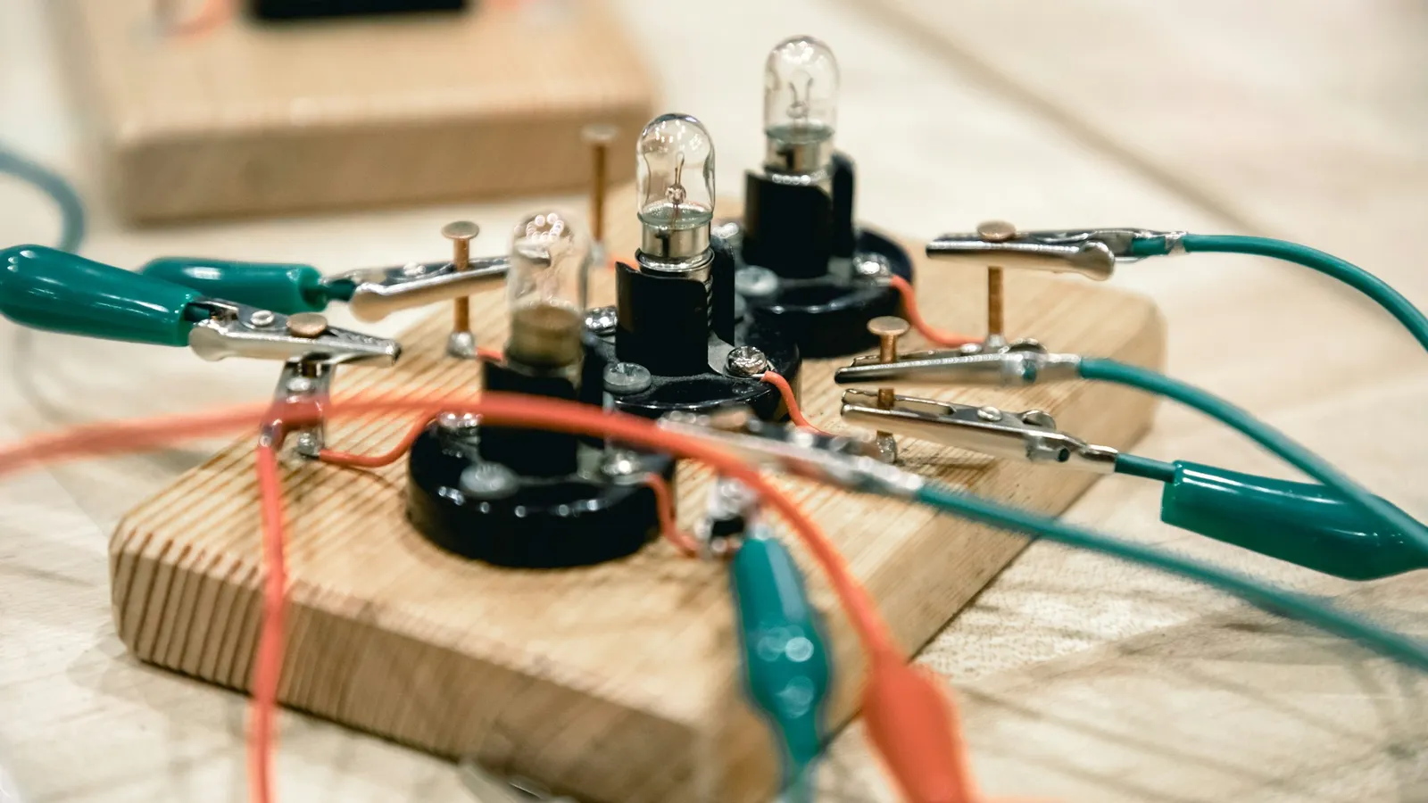 A small circuit wired with crocodile clips on a wooden board