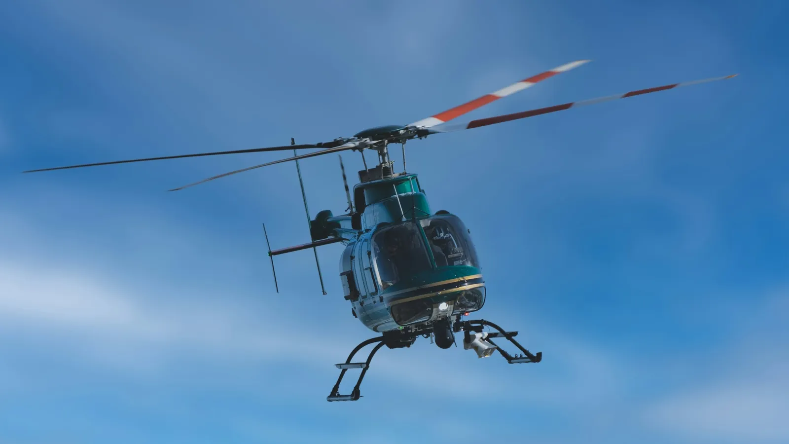 A small helicopter flying in a clear blue sky