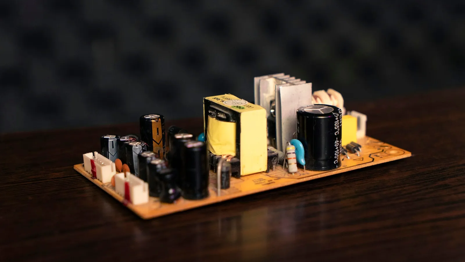 A small power supply circuit board with a transformer and capacitors