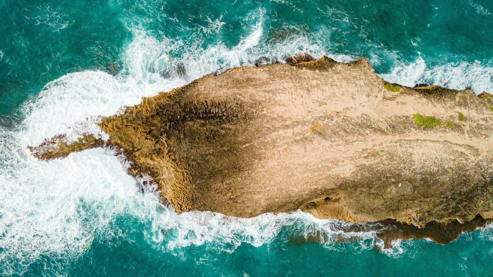 A small rocky island surrounded by turquoise sea