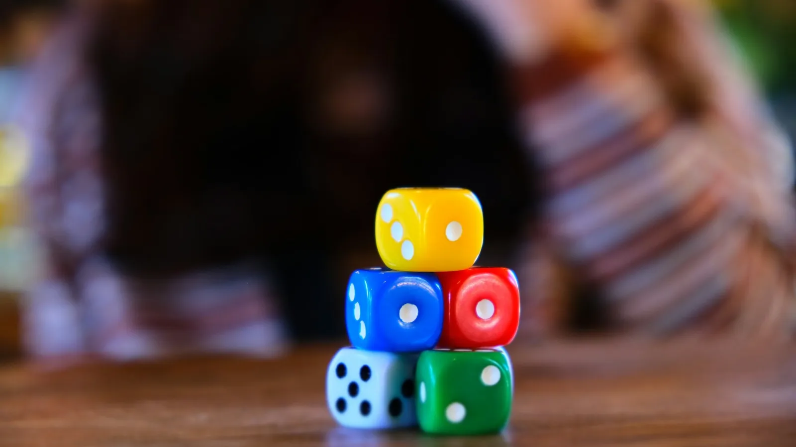 A small stack of colourful dice on a table