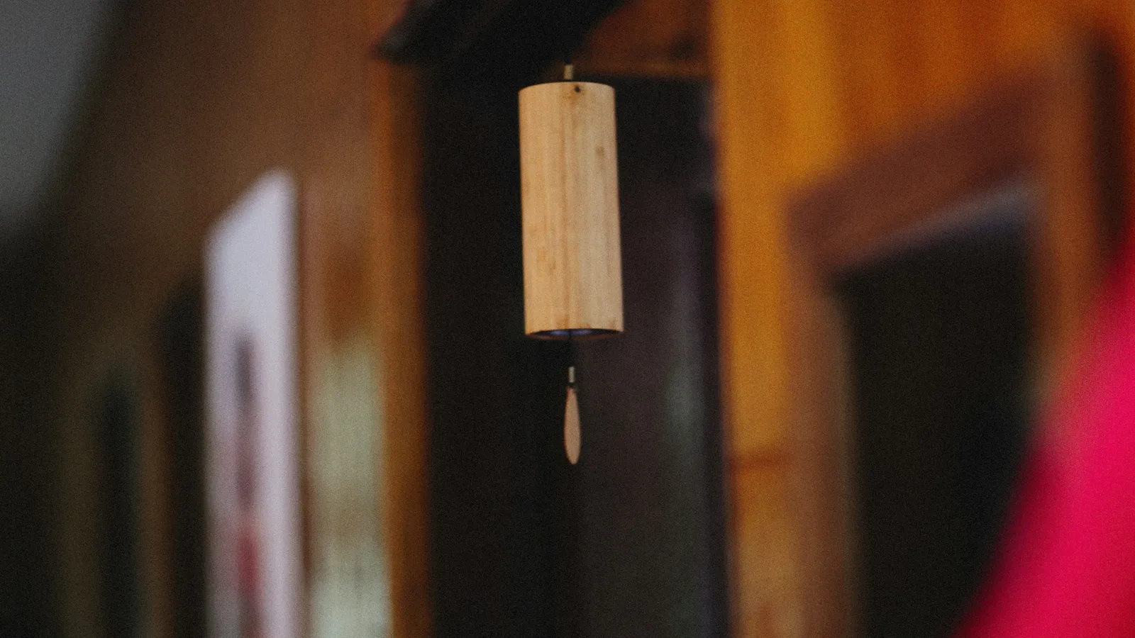 A small wooden block hanging from a string
