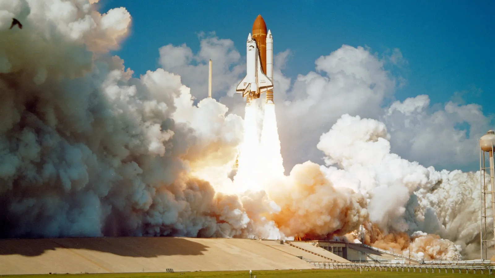 A space shuttle lifting off amid clouds of exhaust