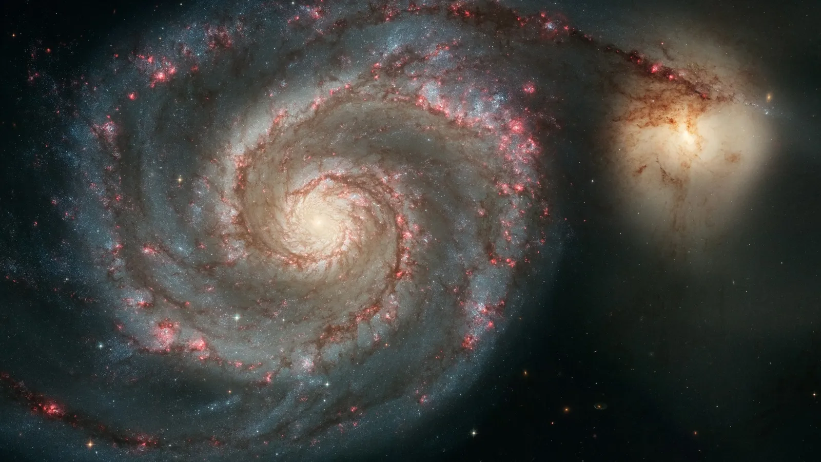 A spiral galaxy with a smaller companion galaxy beside it