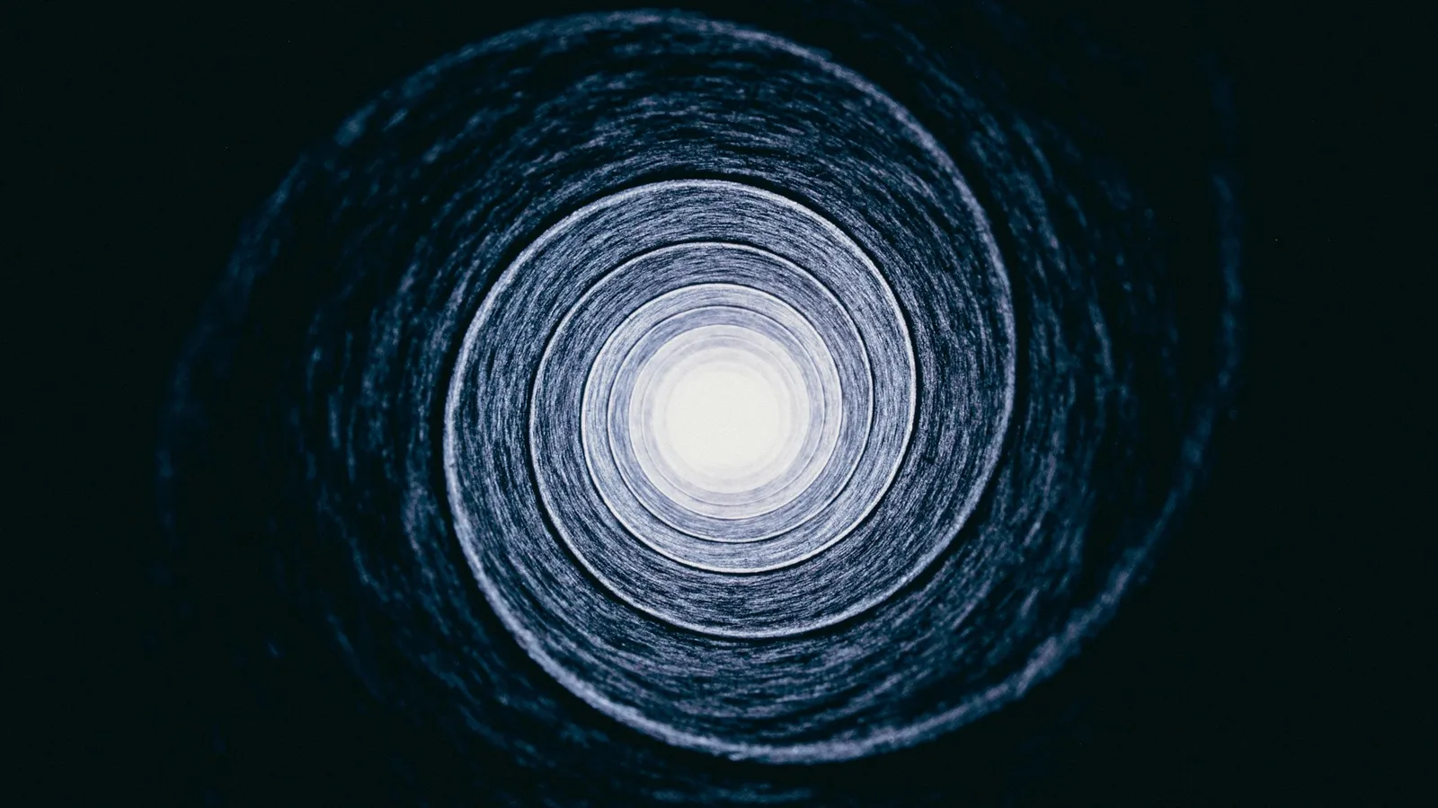 A spiral staircase seen from below, winding inward
