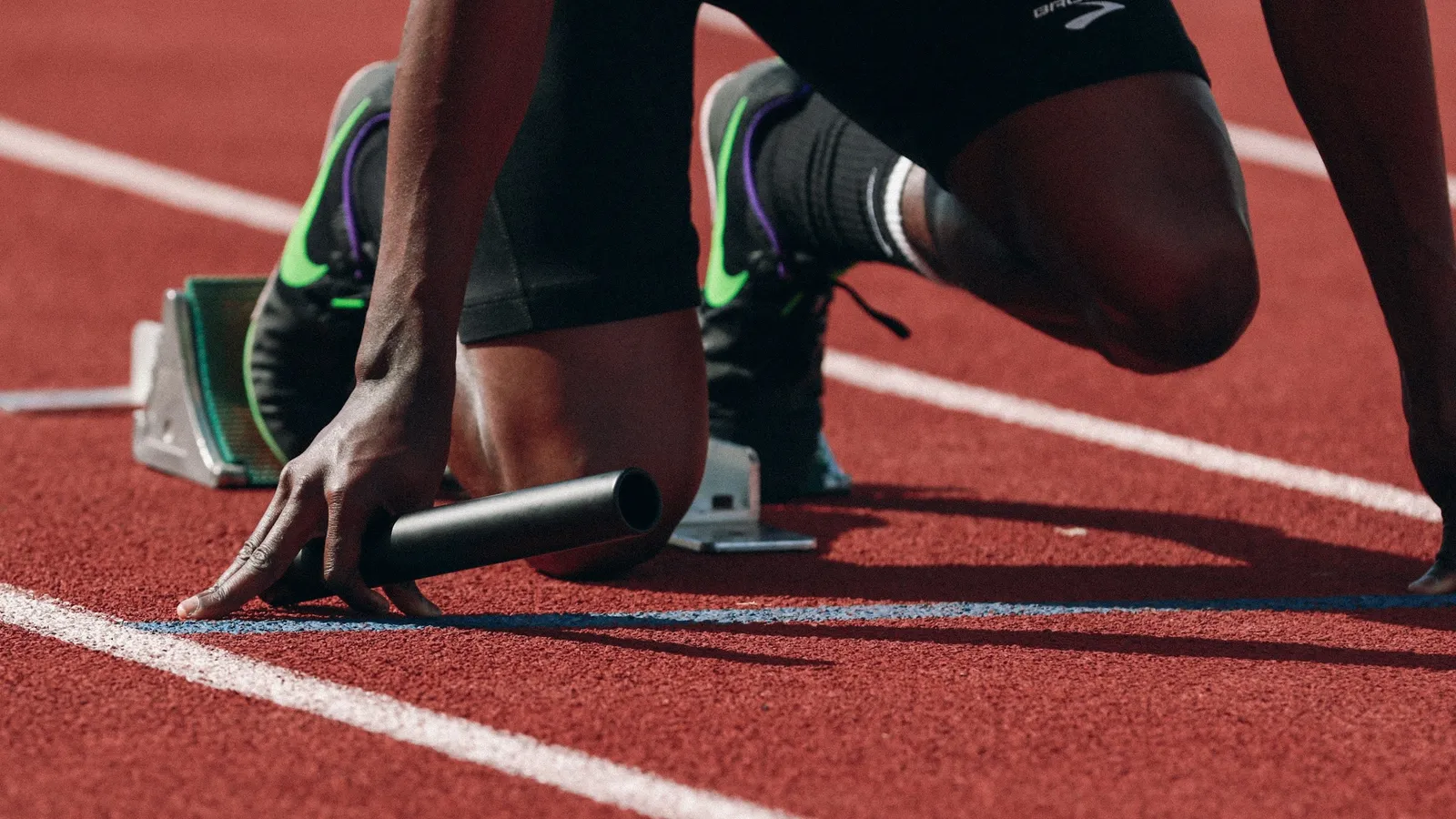 A sprinter crouched on the starting line of a track