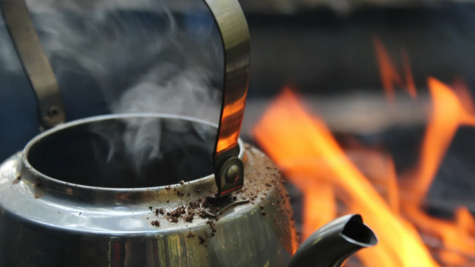 A steaming kettle over an open flame