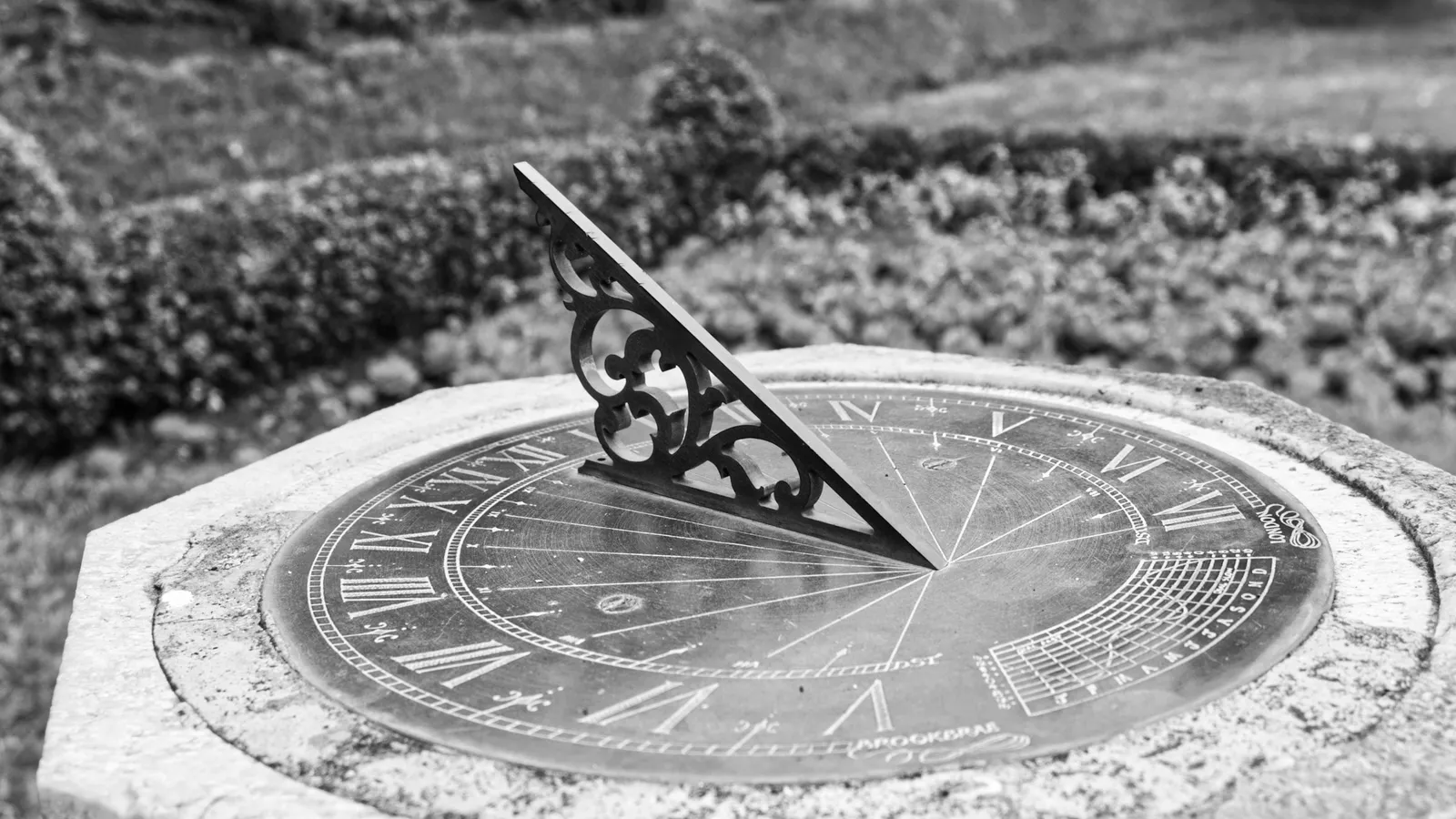 A stone sundial casting a shadow on its dial