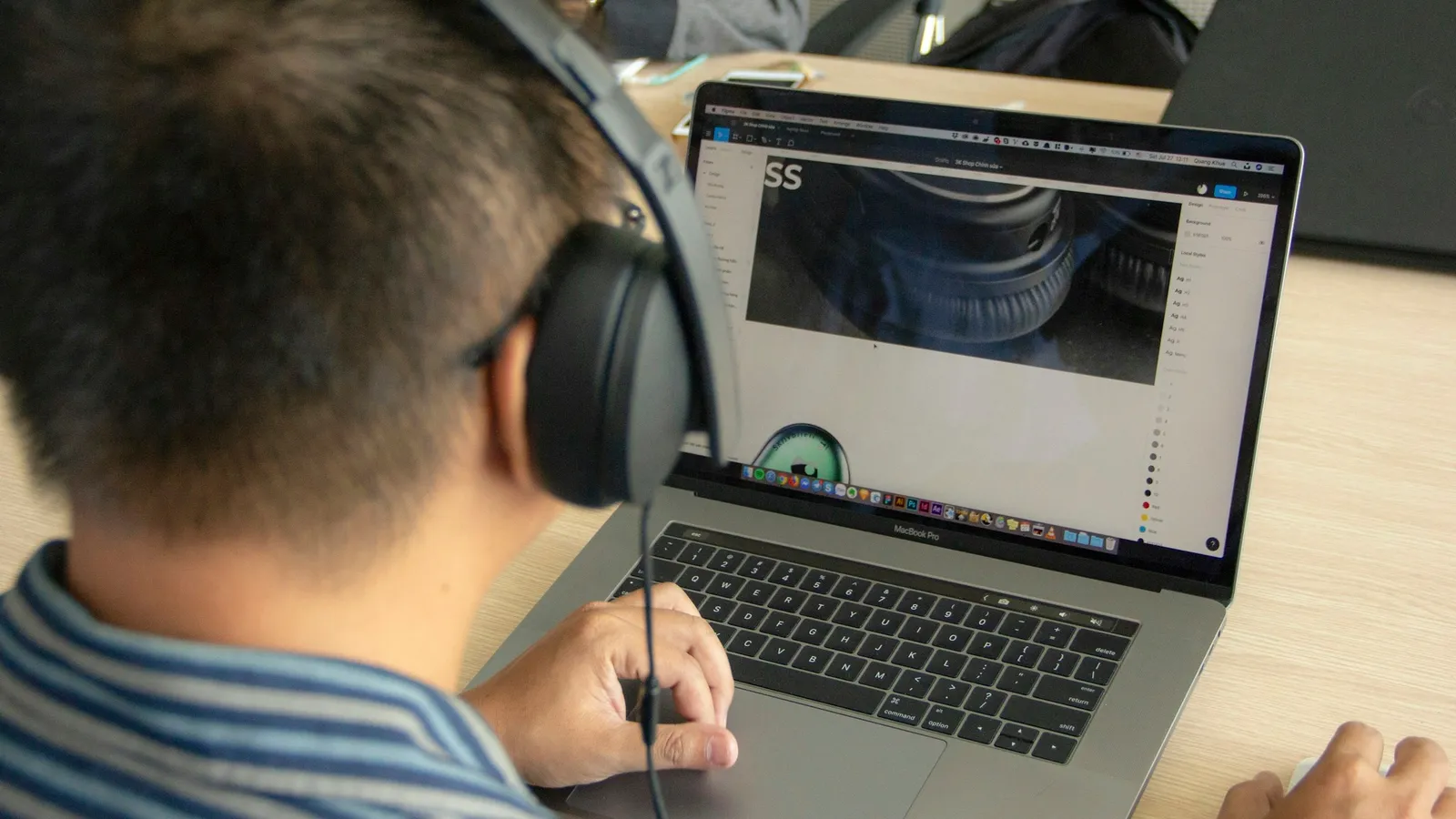 A student wearing headphones watching a video lesson on a laptop