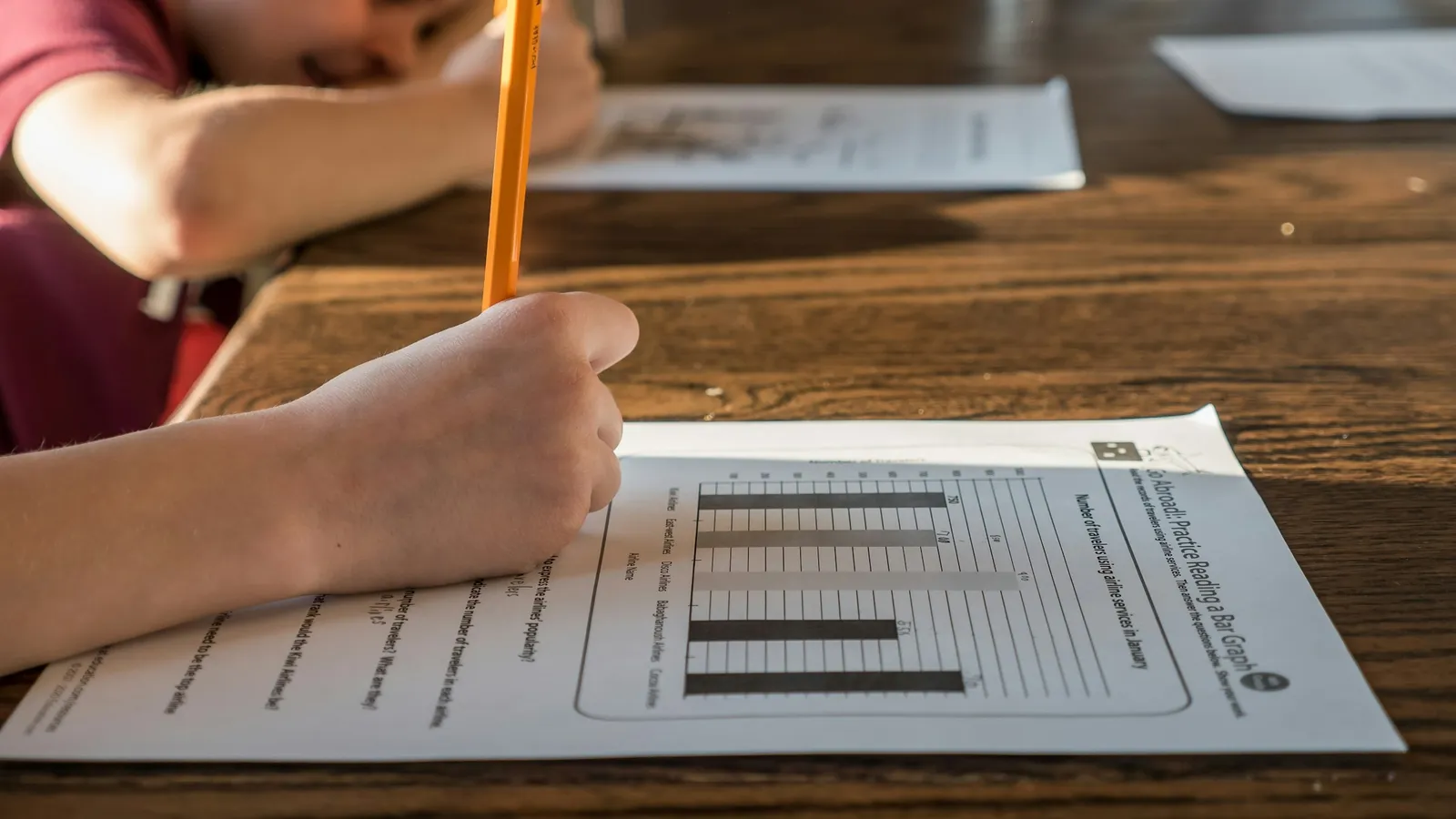 A student writing answers on a worksheet