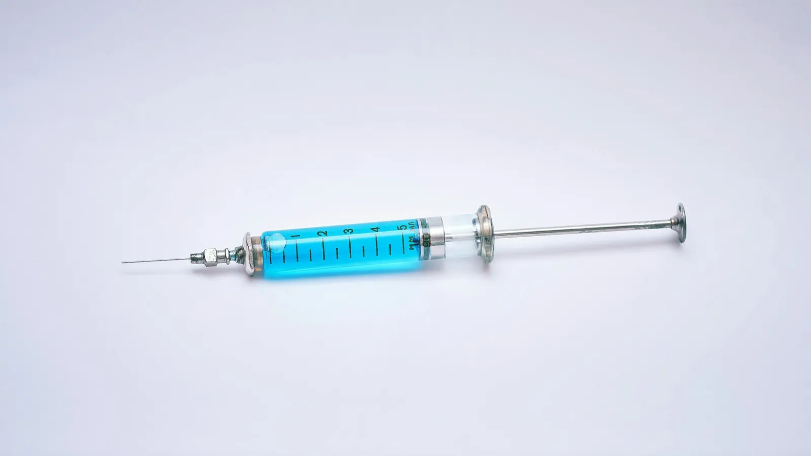 A syringe filled with blue liquid