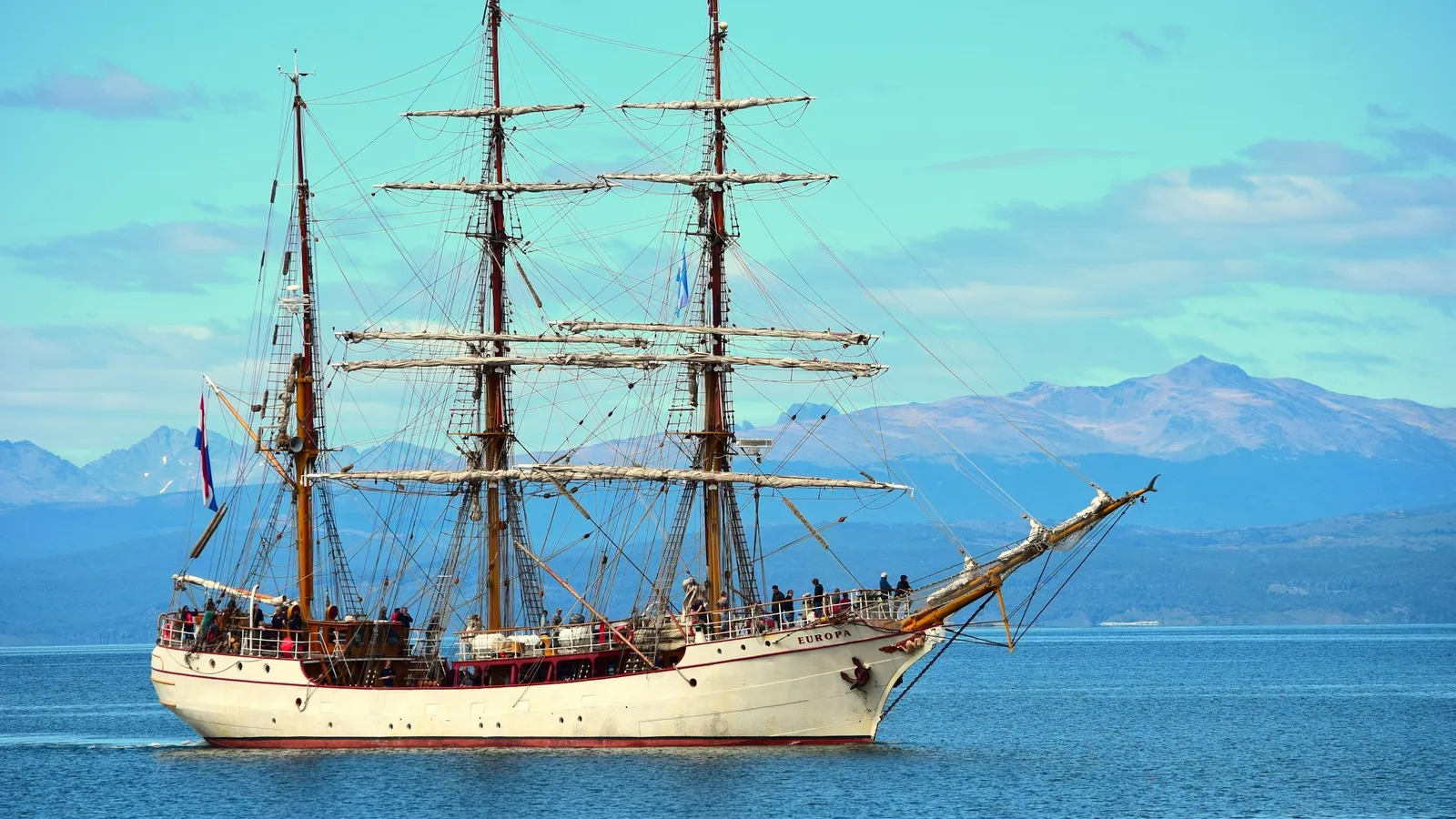 A tall sailing ship on bright blue sea