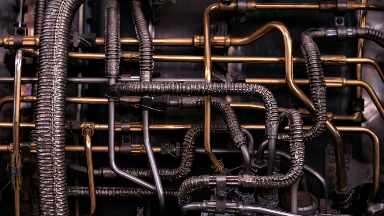 A tangle of old copper pipes on a wall