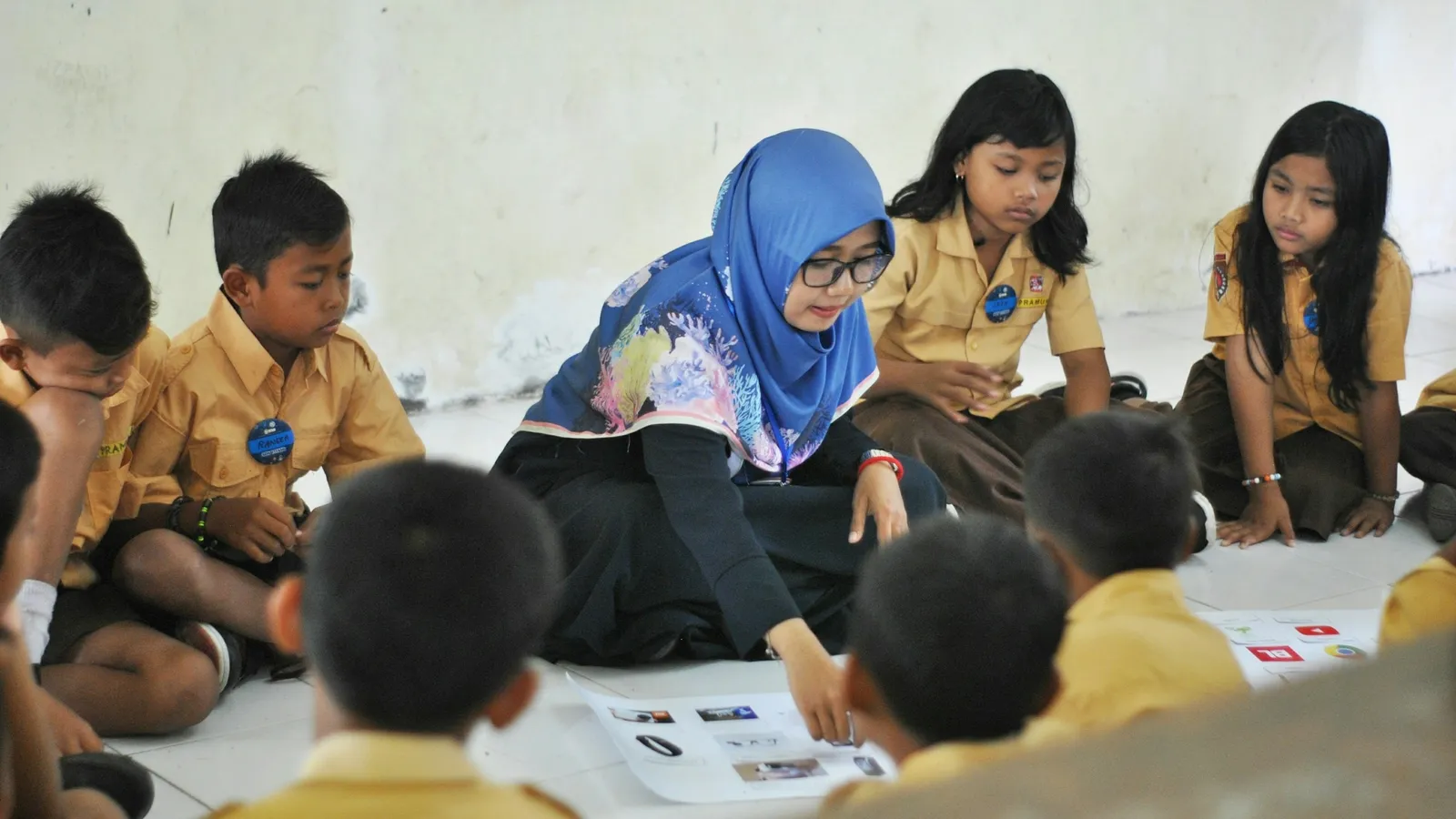A teacher sitting on the floor with a group of young children