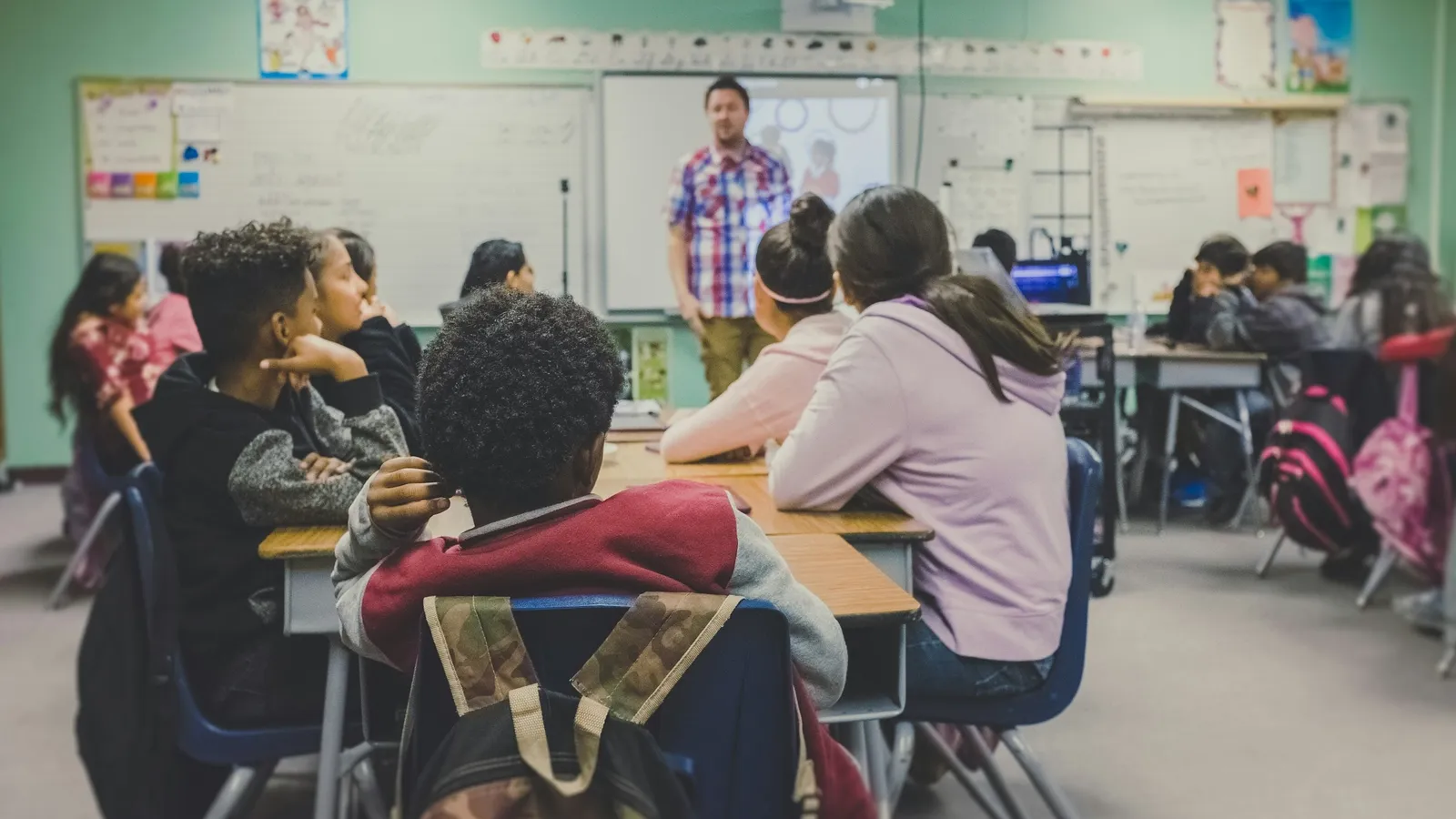 A teacher talking with students in a classroom