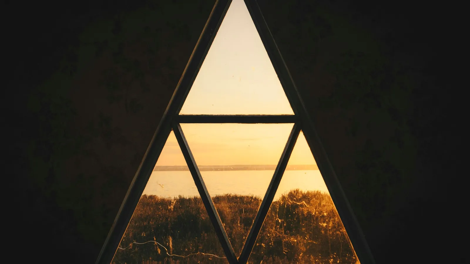 A triangular window frame split into three parts