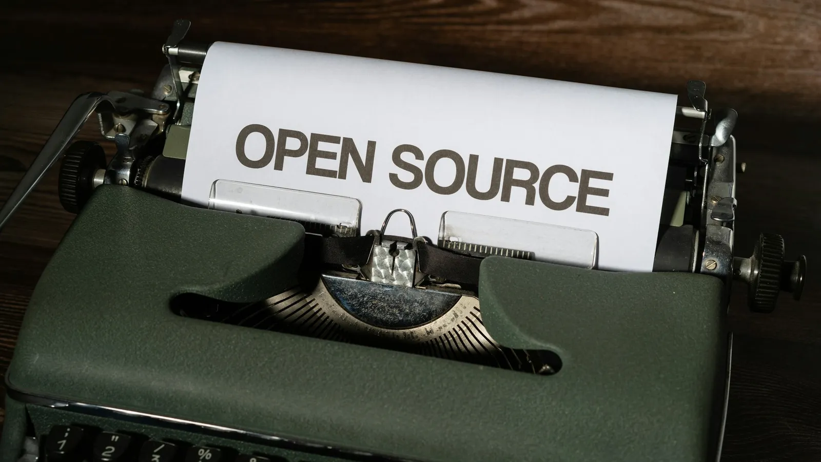 A typewriter with a page reading open source