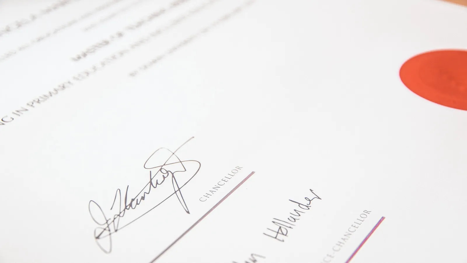 A university certificate with a red seal and two signatures