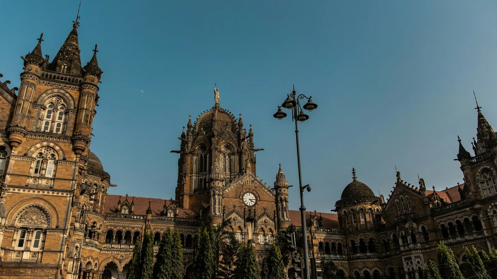 A Victorian Gothic stone building in Mumbai under a blue sky
