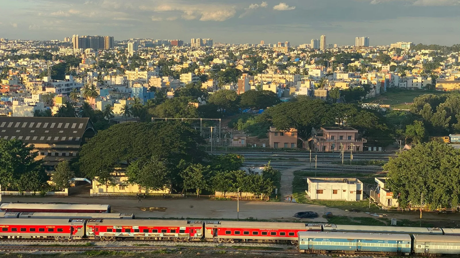 A view over Bengaluru with a train passing through green trees