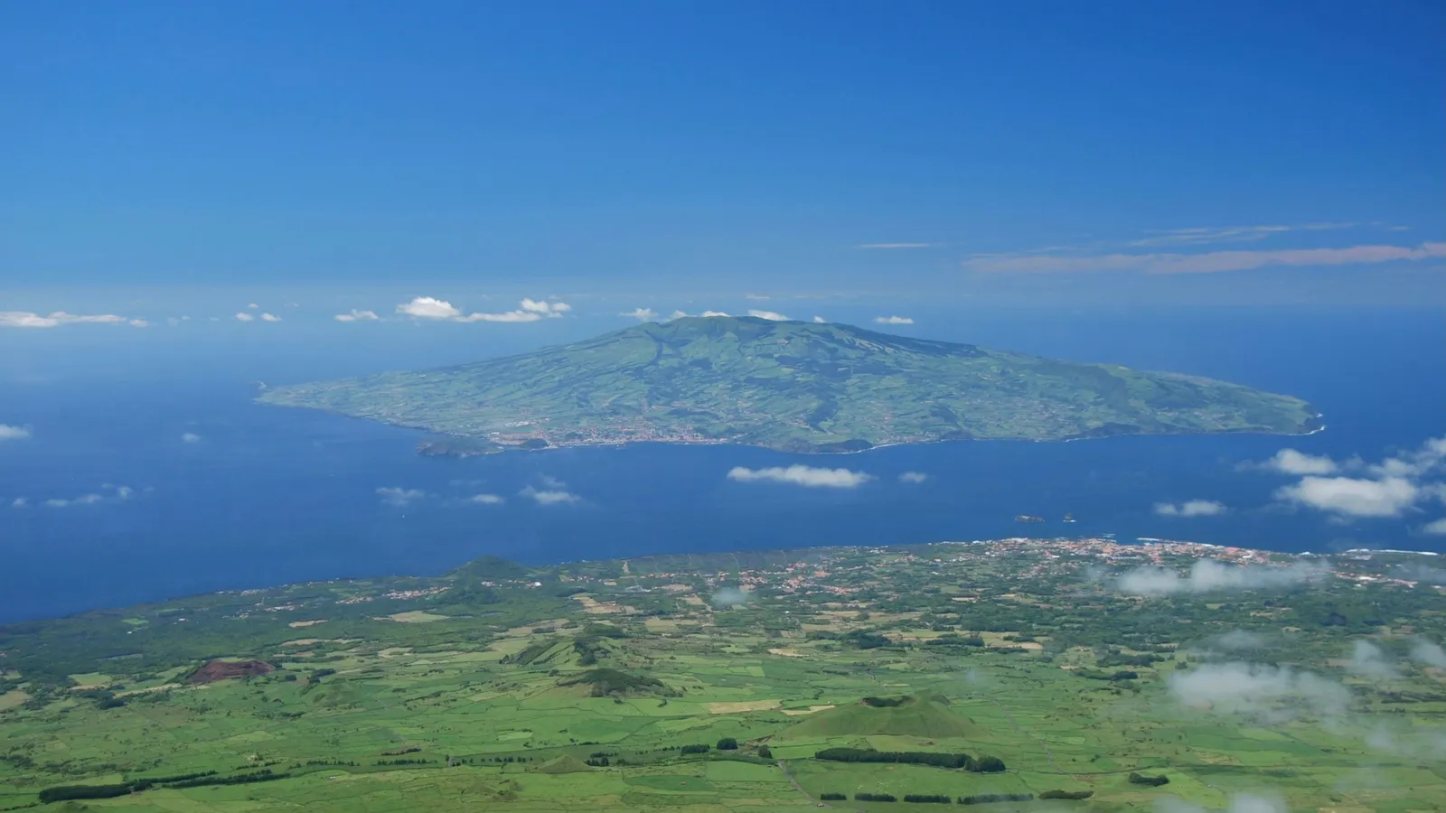 A volcanic island seen from the air in a blue ocean
