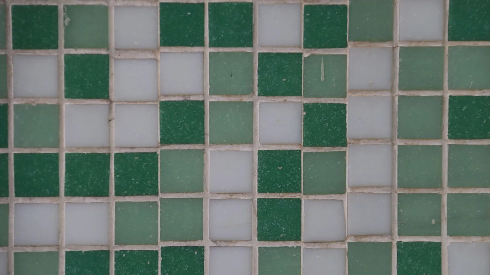A wall of green and white square tiles