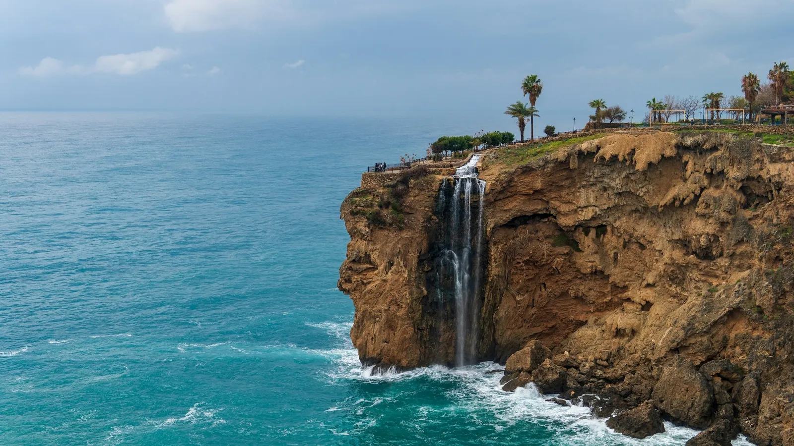 A waterfall pouring off a cliff into the sea