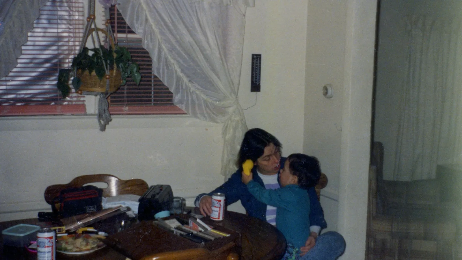 A woman and child sitting close together at a wooden table