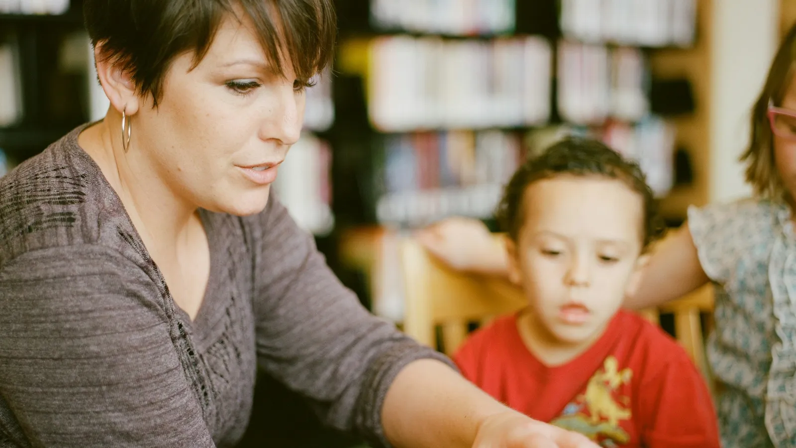 A woman explaining something to a boy at a table