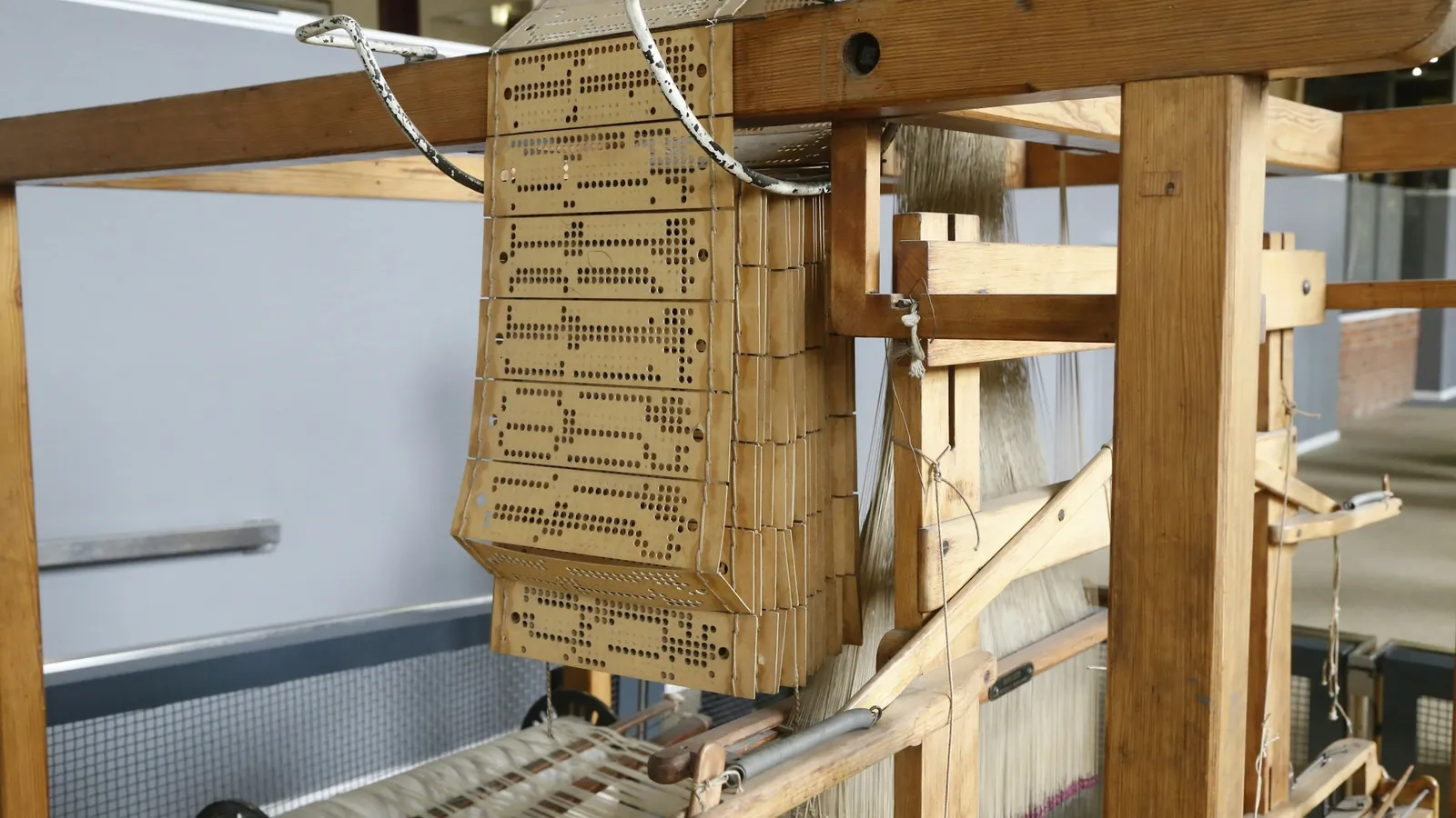 A wooden loom with a chain of punched cards