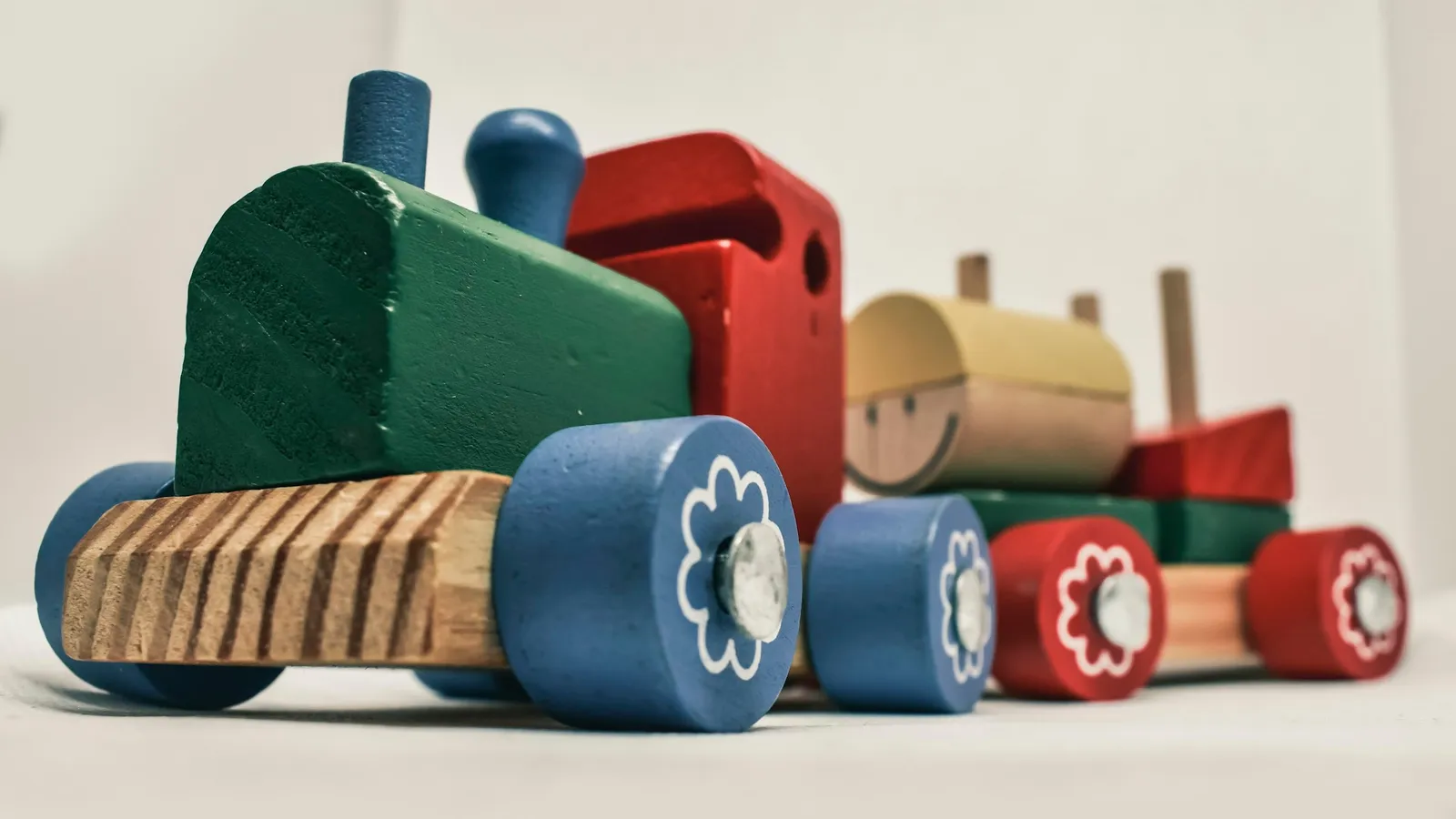 A wooden toy train with linked carriages