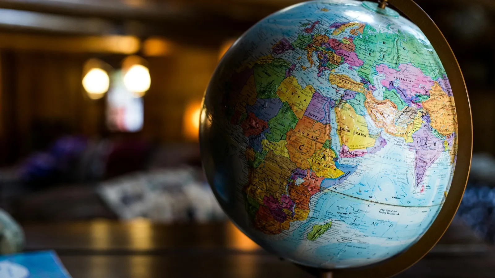A world globe lit by warm light in a dim room