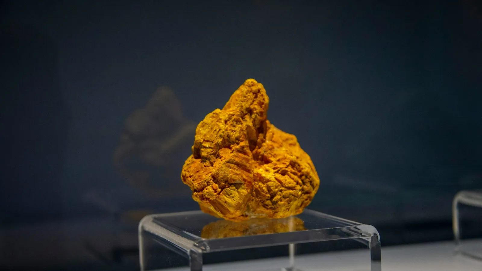 A yellow mineral sample on display