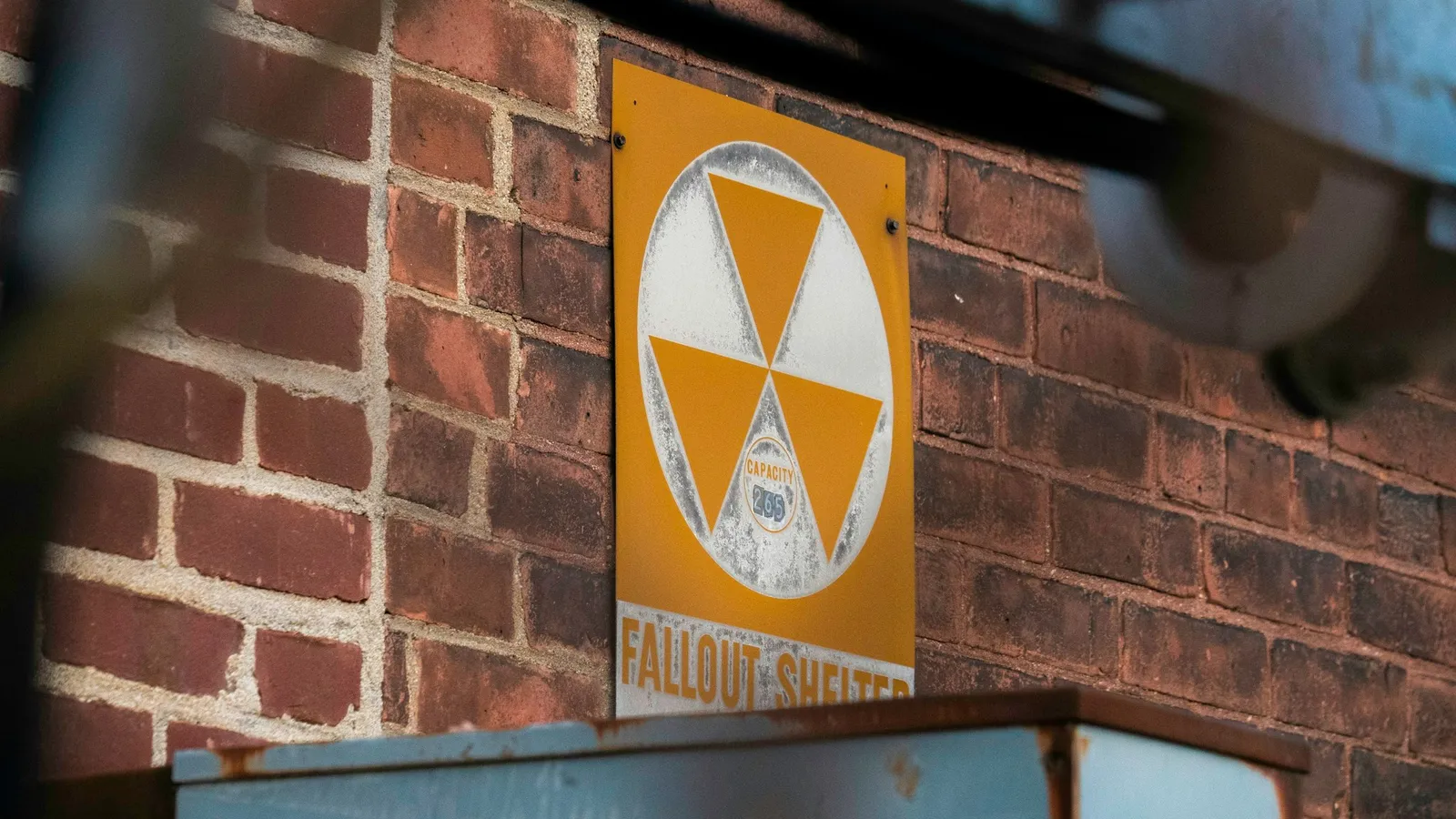 A yellow radiation warning sign on a brick wall