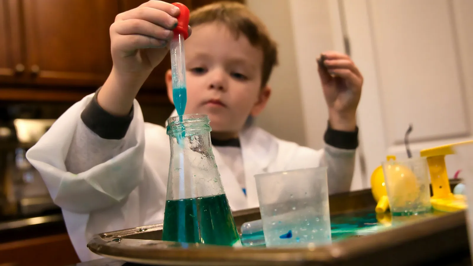 A young boy doing a science experiment with coloured liquids