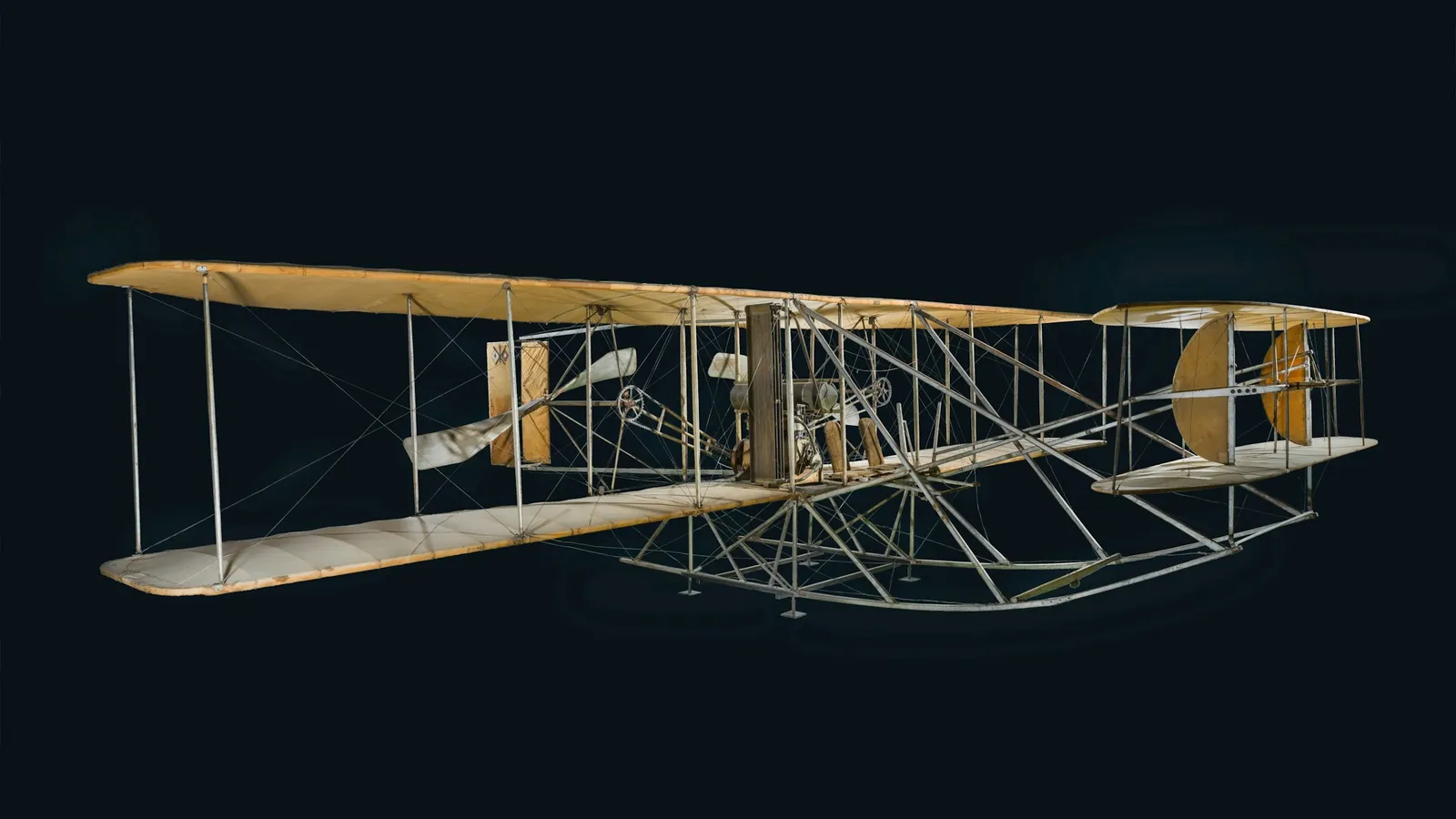 An early wood and fabric biplane shown against black