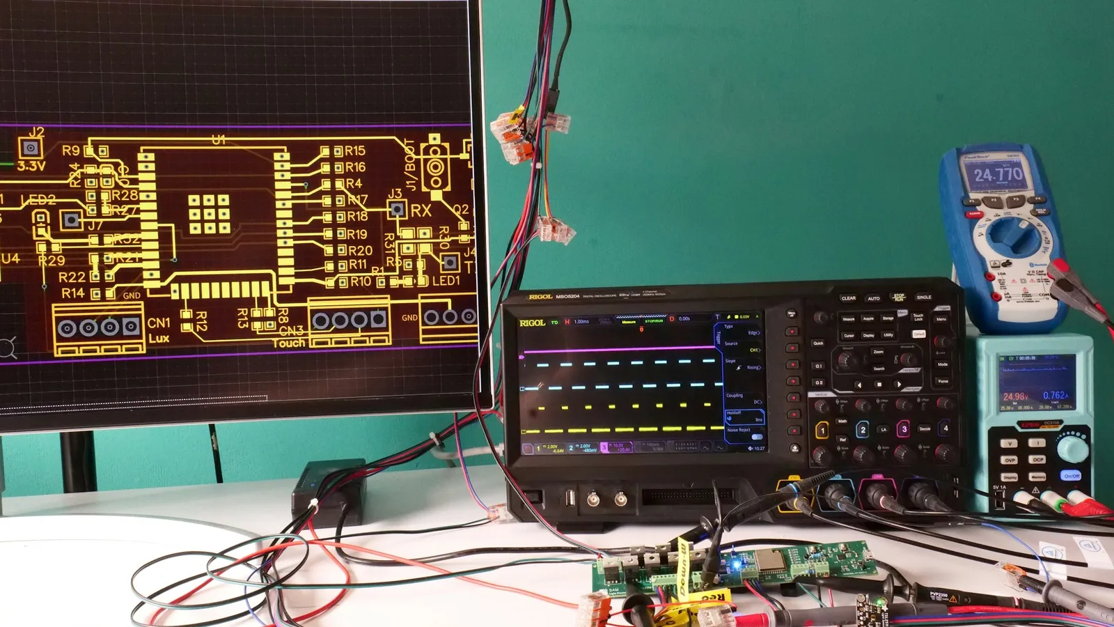 An electronics workbench with an oscilloscope, a multimeter and a circuit board