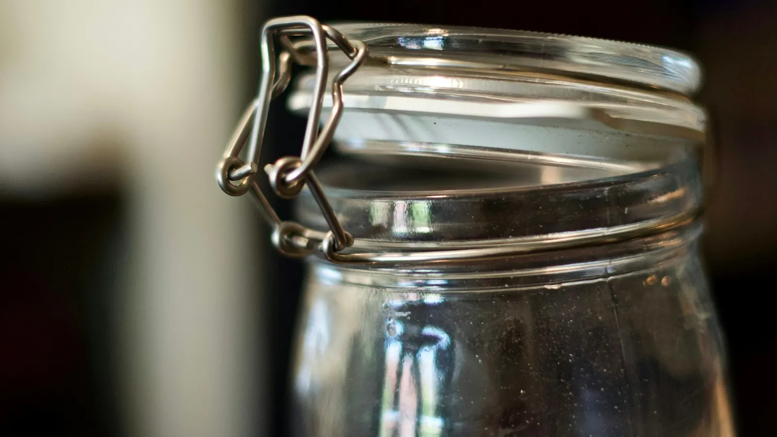 An empty glass jar with a clip-top lid in soft light
