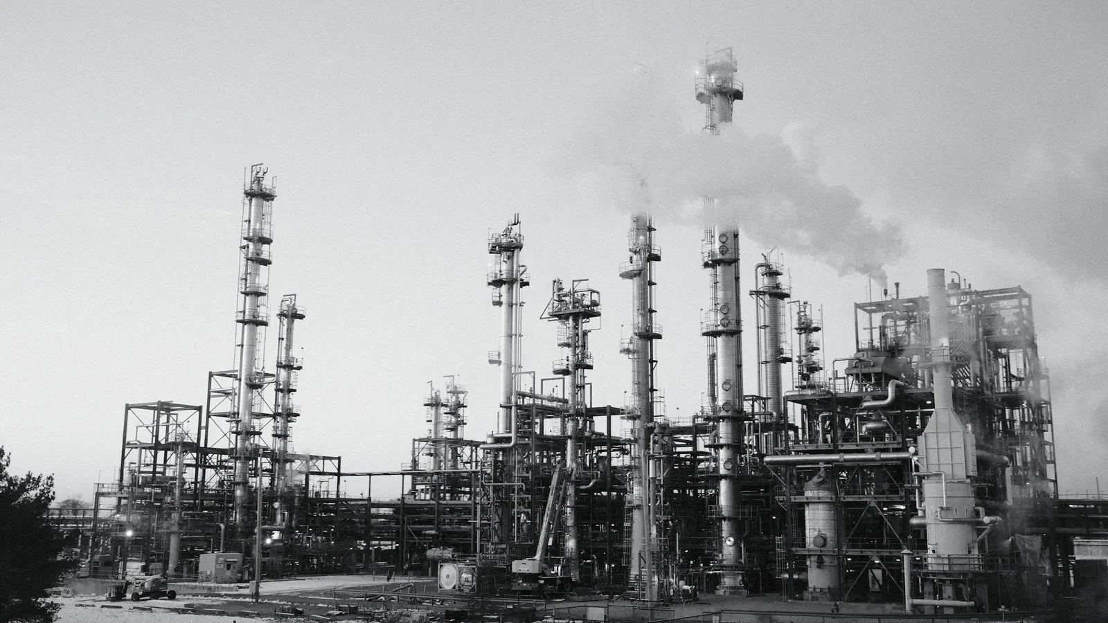 An industrial chemical plant with towers and pipes, in black and white