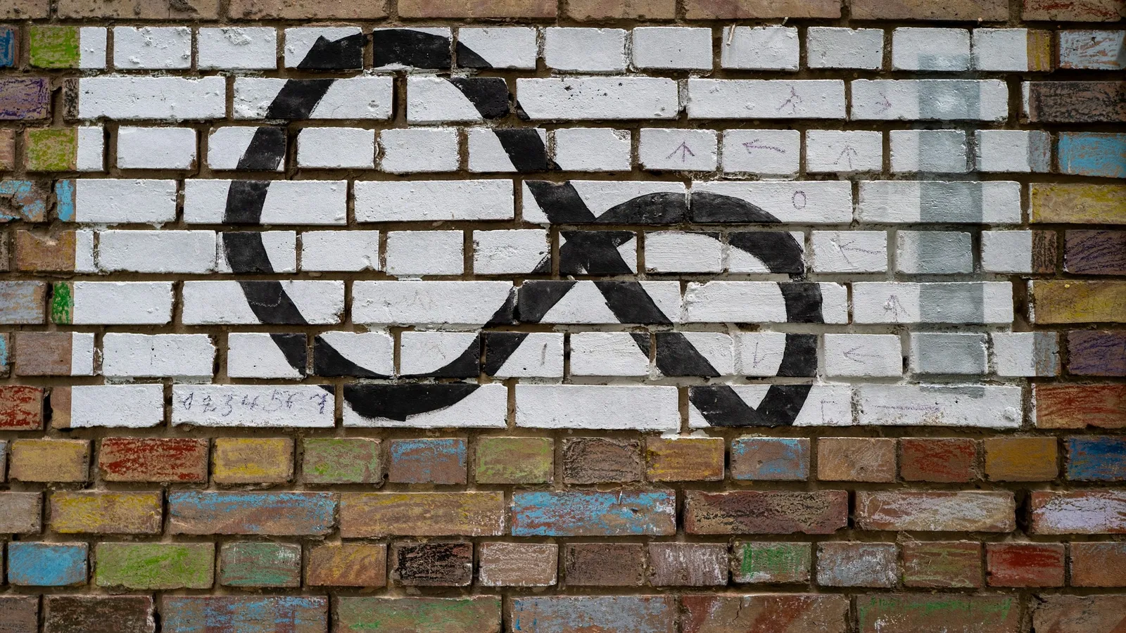 An infinity symbol painted on a brick wall