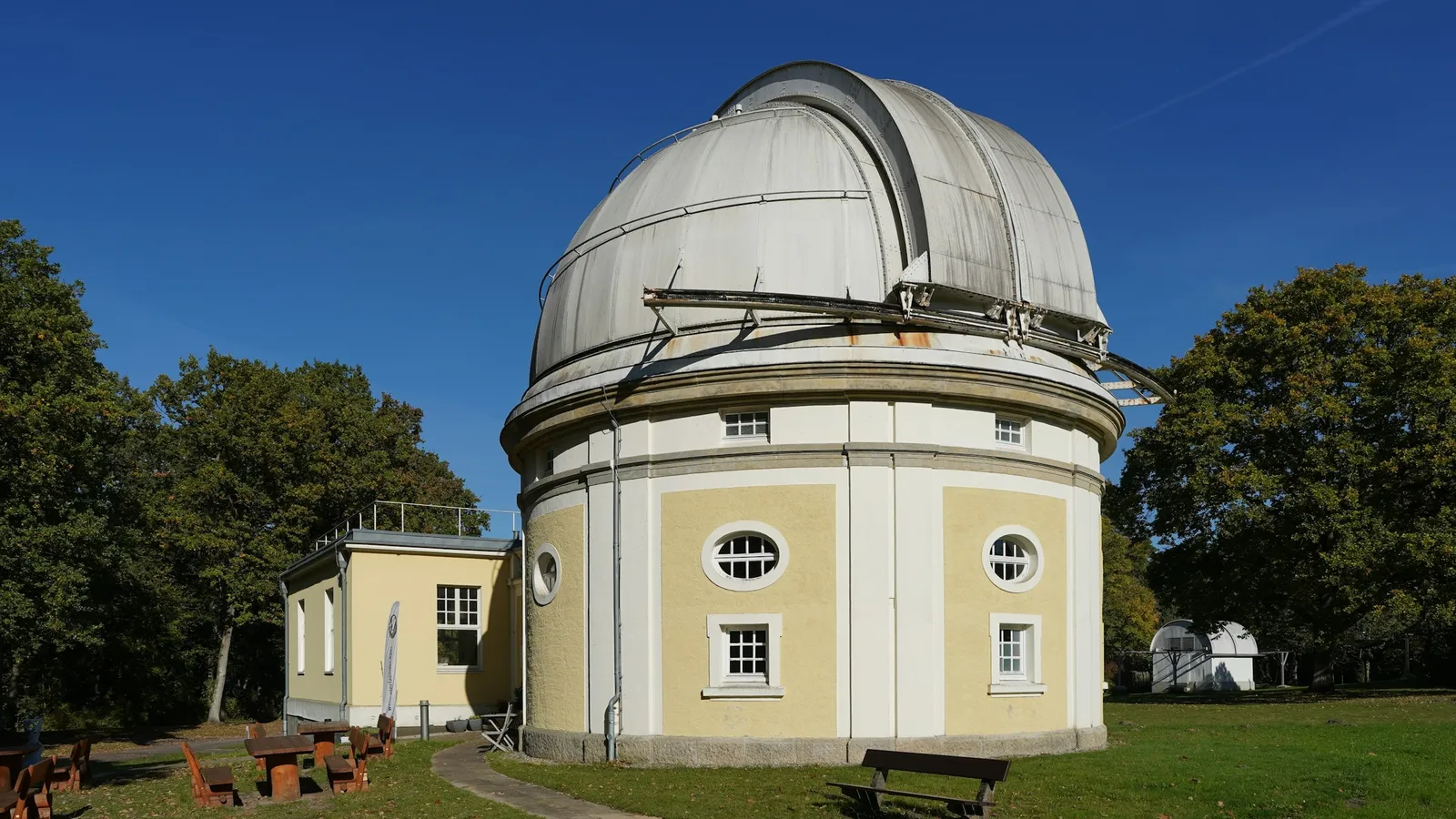 An observatory building with a white dome under a blue sky