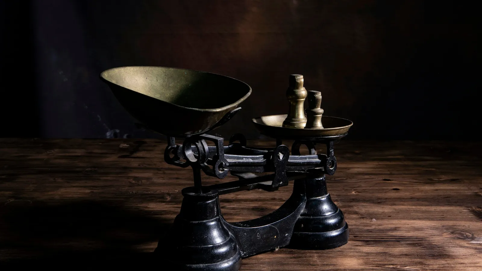 An old balance scale on a dark wooden table