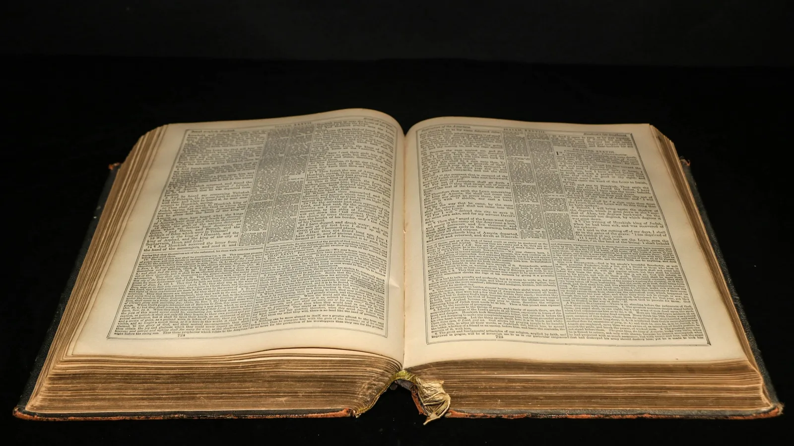 An old book lying open on a dark table
