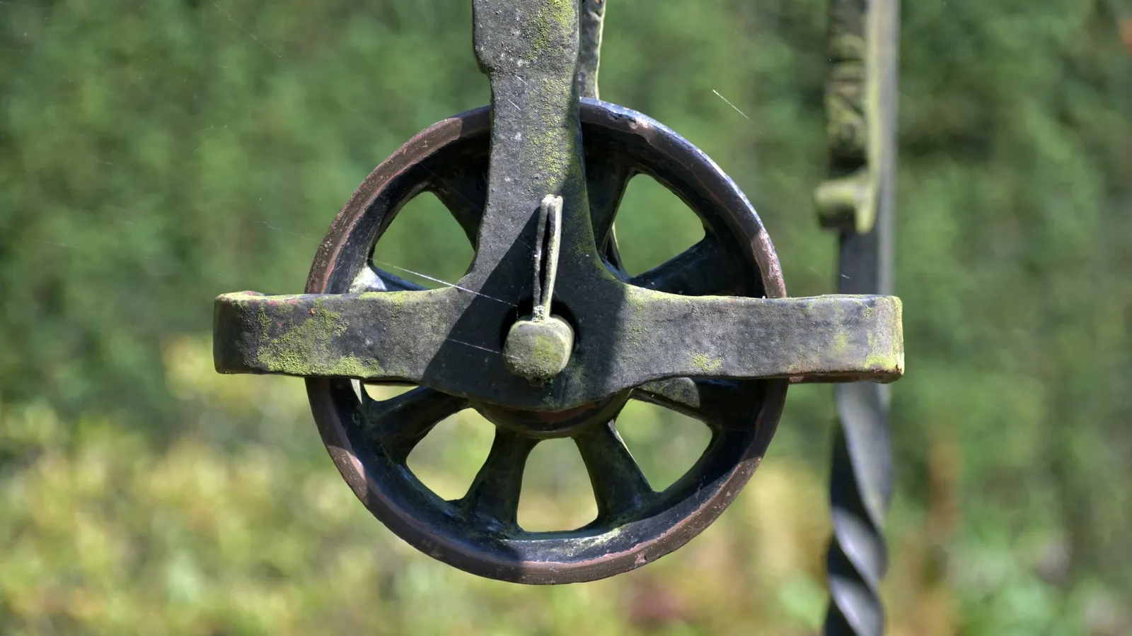 An old iron pulley wheel with a rope