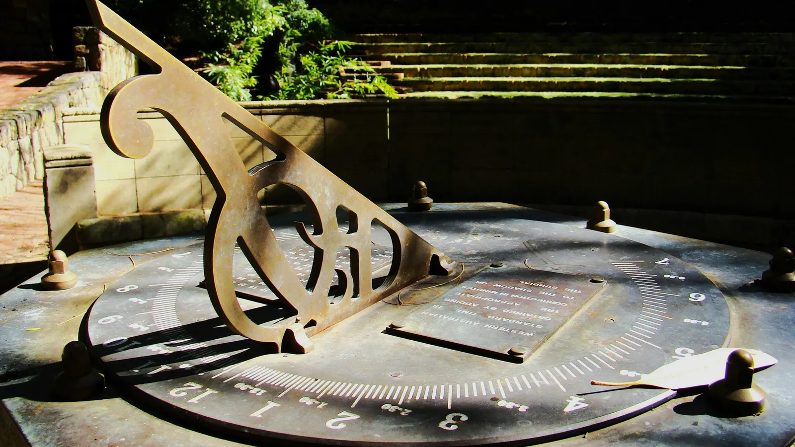 An old metal sundial casting a shadow