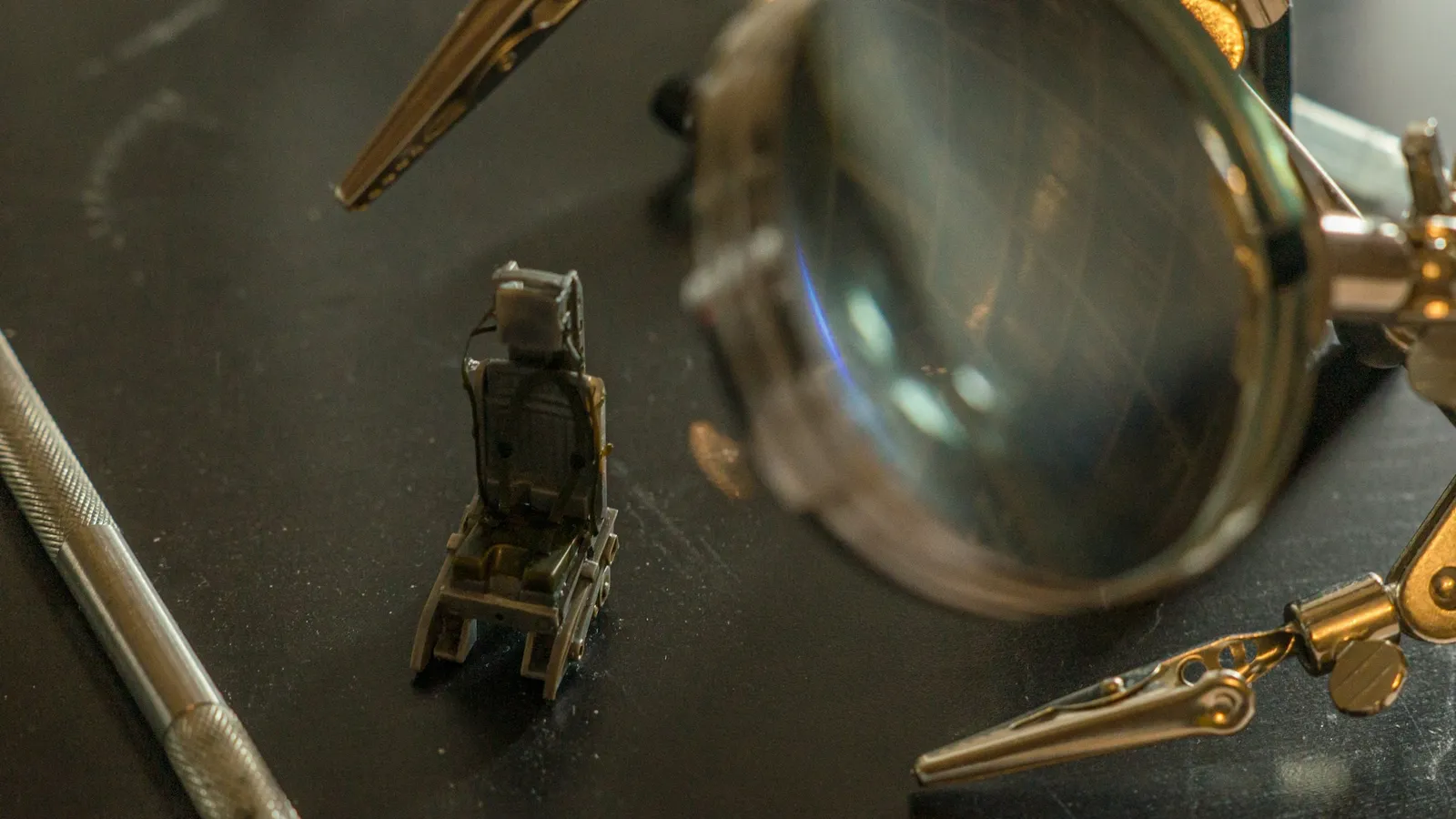 An old microscope part beside a magnifying glass