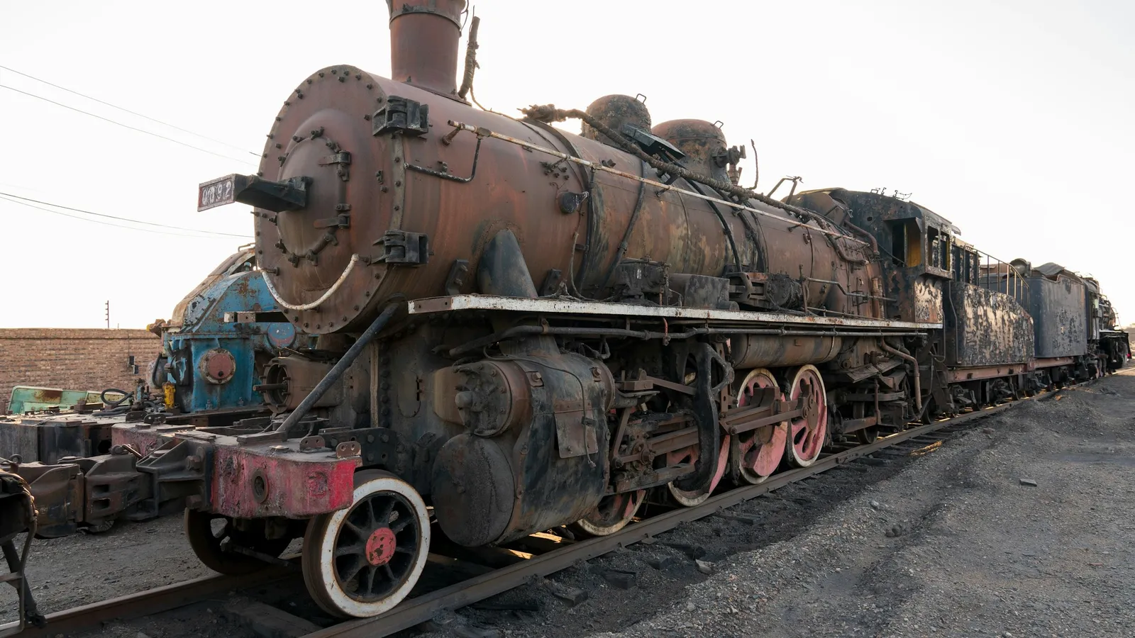 An old steam locomotive in a rail yard